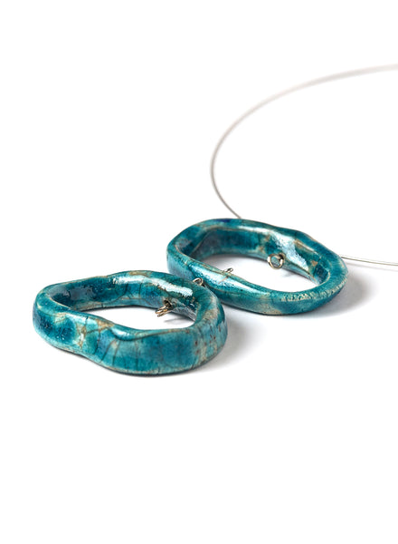 Collana Ojos con pendenti ovali in ceramica Raku con sfumature turchesi e girocollo in acciaio