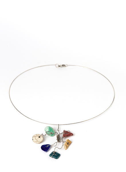 Collana leggera e contemporanea con filo d'acciaio armonico che lega un insieme vivace di piccoli elementi in ceramica Raku smaltata. 
