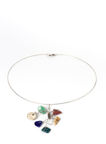 Collana leggera e contemporanea con filo d'acciaio armonico che lega un insieme vivace di piccoli elementi in ceramica Raku smaltata. 