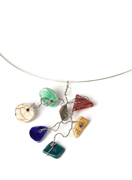 Collana leggera e contemporanea con filo d'acciaio armonico che lega un insieme vivace di piccoli elementi in ceramica Raku smaltata