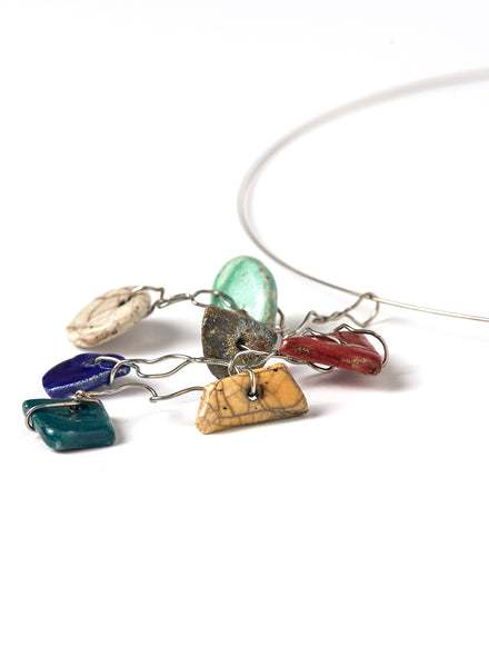 Collana leggera e contemporanea con filo d'acciaio armonico che lega un insieme vivace di piccoli elementi in ceramica Raku smaltata.