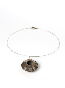 Collana realizzata a mano, con pendente in ceramica Raku di forma circolare oro e nero fumo.
