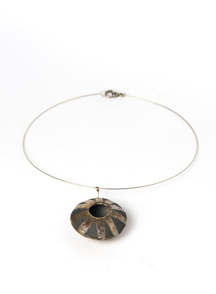 Collana realizzata a mano, con pendente in ceramica Raku di forma circolare oro e nero fumo.
