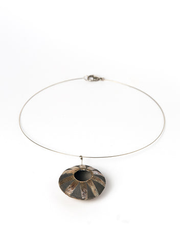 Collana realizzata a mano, con pendente in ceramica Raku di forma circolare oro e nero fumo.
