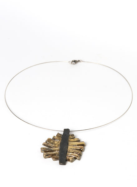 Collana con pendente in ceramica Raku con strisce oro cangiante che si appoggiano su una base nero fumo. 