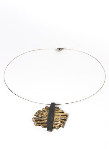 Collana con pendente in ceramica Raku con strisce oro cangiante che si appoggiano su una base nero fumo. 