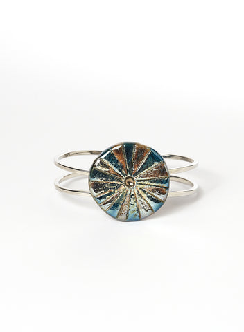 Bracciale rigido in lega con elemento in ceramica Raku, caratterizzato da un disco con luminose striature dorate.