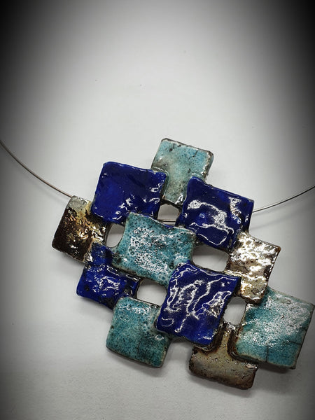 Collana fatta a mano in ceramica raku. pixel di azzurri , blu e oro