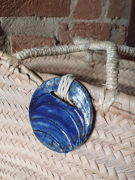 borsa in paglia intrecciata con gioiello in ceramica Raku