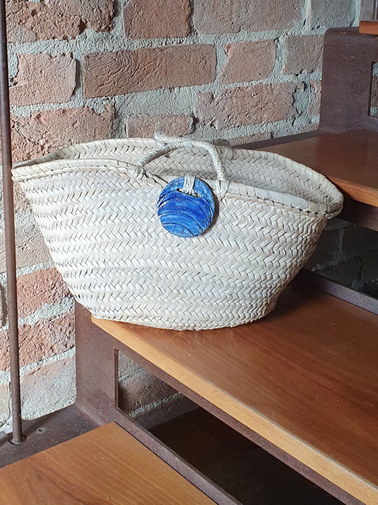 borsa in paglia intrecciata con gioiello in ceramica Raku