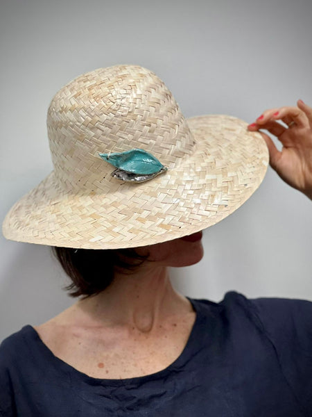 cappello in paglia naturale con accessorio-gioiello fatto a mano in ceramica Raku. foglie azzurro e oro