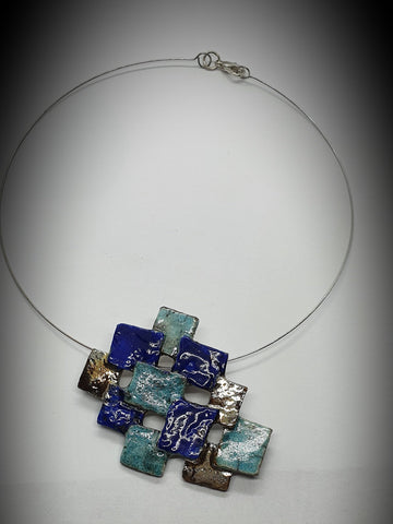 Collana fatta a mano in ceramica raku. pixel di azzurri , blu e oro