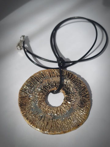 collana fatta a mano in ceramica raku. tondo colore oro