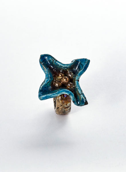 anello fatto a mano in ceramica raku, dalle forme irregolari e con paline in ceramica in centro. colore azzurro e oro