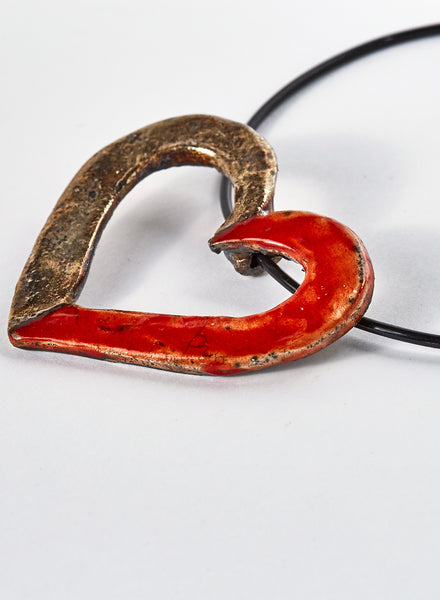 collana fatta a mano in ceramica raku a forma di cuore bicolore. Rosso e oro