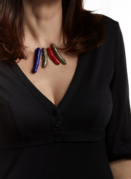 Collana Dolca, con piccoli amuleti colorati fatti a mano in ceramica Raku blu, rosso e oro e girocollo rigido in acciaio