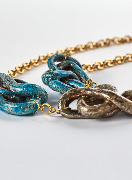 collana ad anelli dorati con decorazioni fatte a mano in ceramica raku. color oro e azzurro.