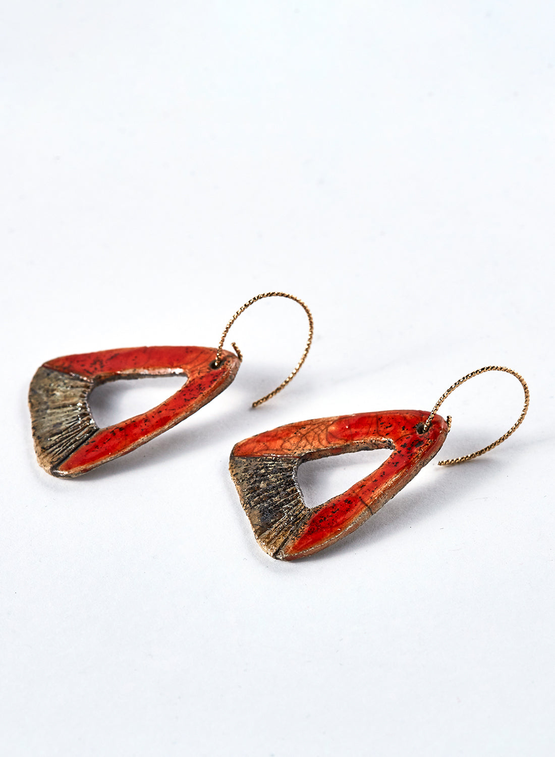 Orecchini fatti a mano in ceramica raku. piccoli triangoli rosso e oro