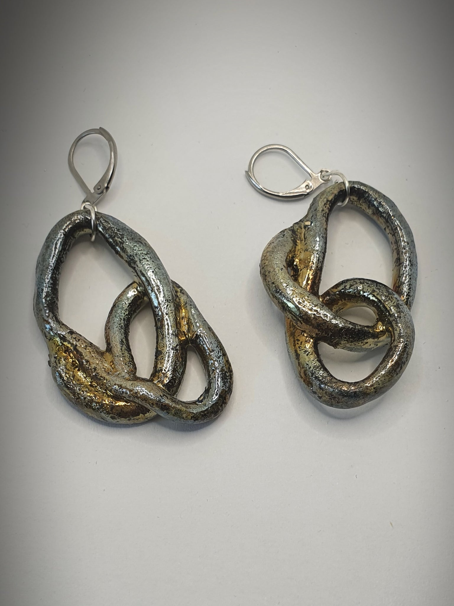 orecchini fatti a mano in ceramica raku. colore oro e forme morbide